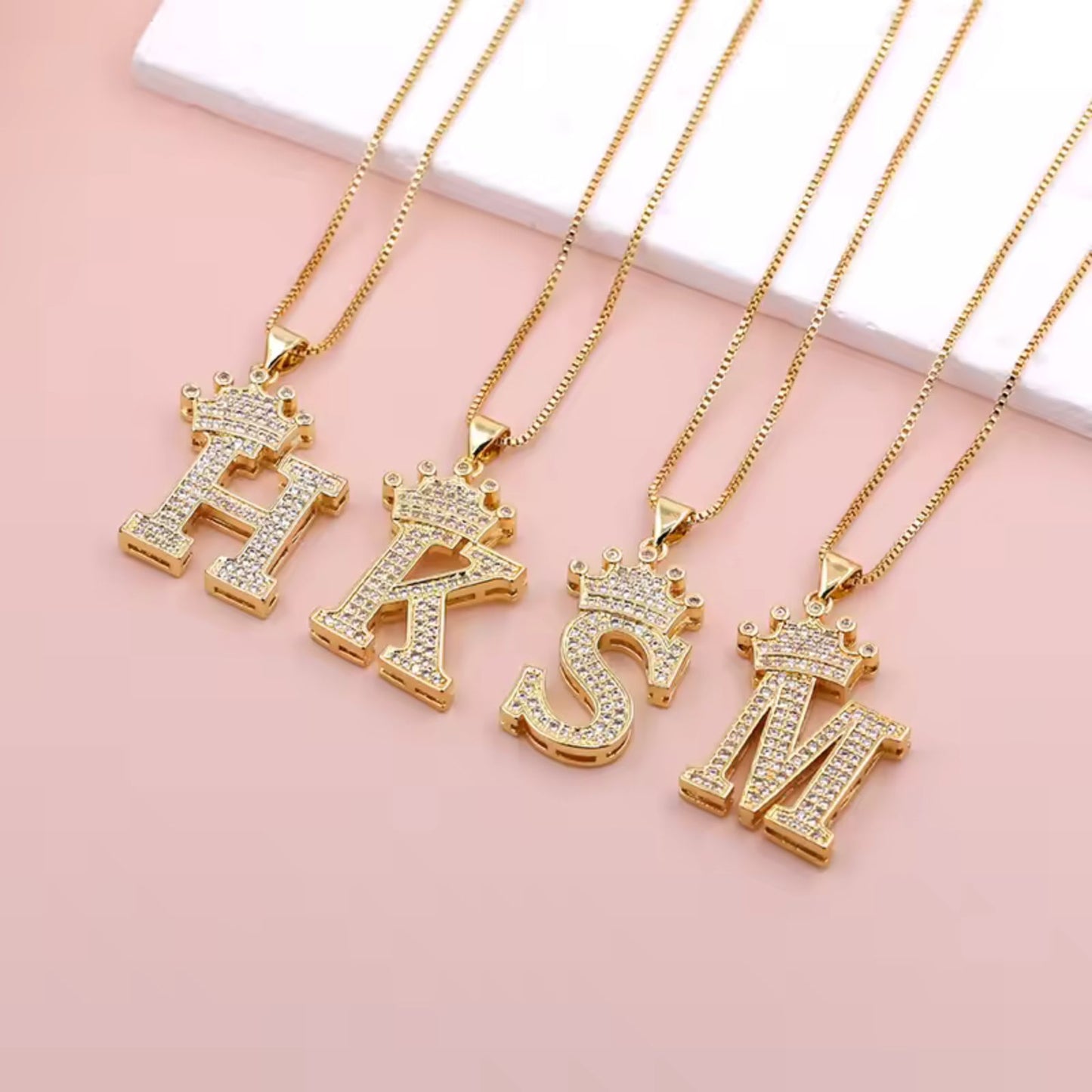 Necklace with English crown letter pendant and white cubic zirconia.